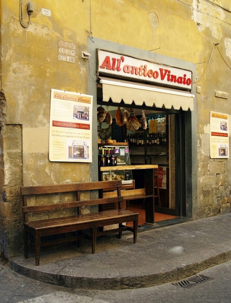 La fachada del local con la banca vacía y nadie en la puerta.